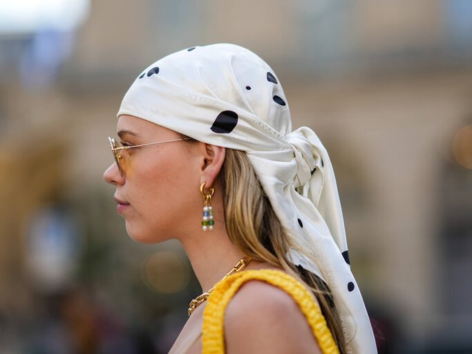 Frau trägt ein modisches Kopftuch in ihrem Haar | © Getty Images/Edward Berthelot 