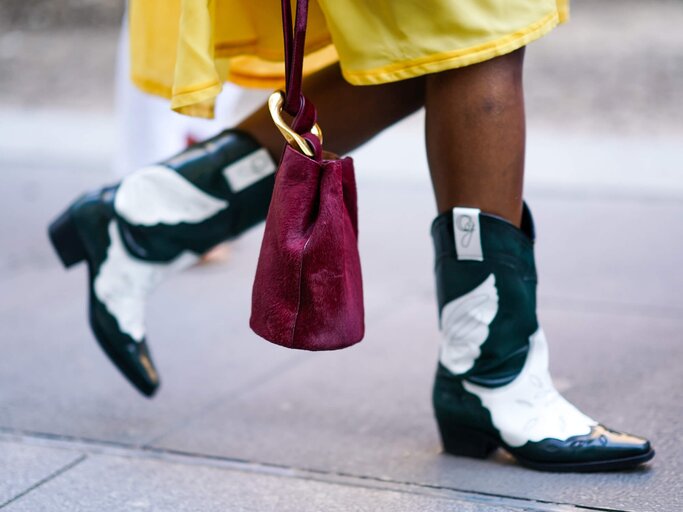 Street Style mit Cowboy Boots zu gelbem Kleid | © Getty Images/Edward Berthelot / Kontributor