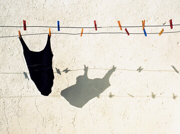 Schwarzer Badeanzug hängt an Wäscheleine | © Getty Images/Jonathan Kirn