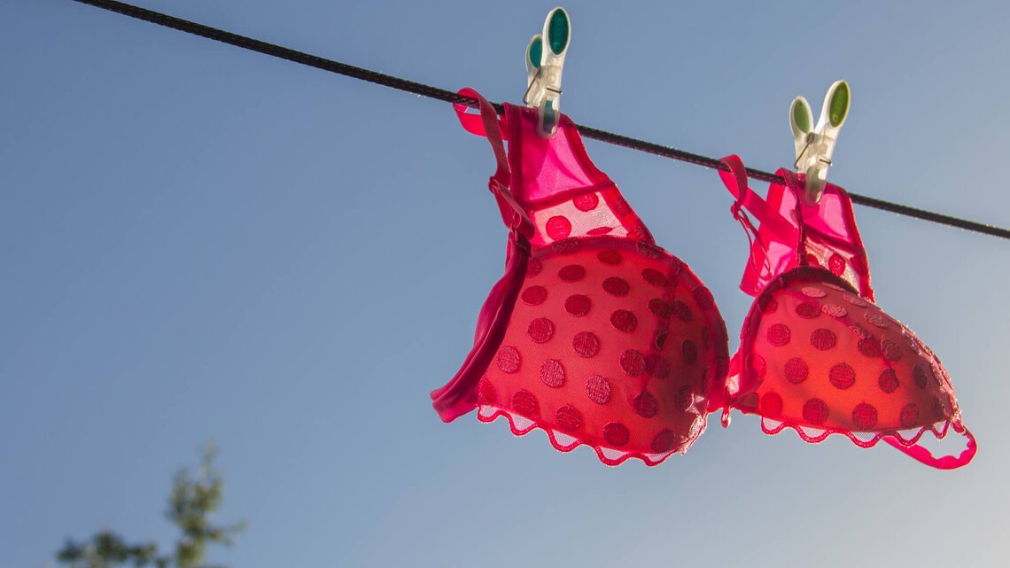 Roter gepunkteter BH hängt an der Wäscheleine | © Getty Images/Sinicakover