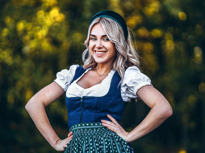 Frau trägt Dirndl und lächelt in die Kamera. | © shuterstock/bedya