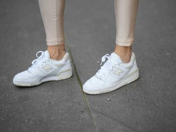 Nahaufnahme von goldenen Leggings und Sneakern | © Getty Images/Edward Berthelot 