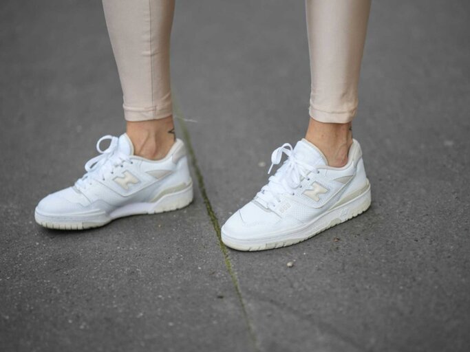 Nahaufnahme von goldenen Leggings und Sneakern | © Getty Images/Edward Berthelot 