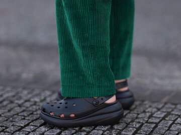 Frau trägt Schwarze Crocs und grüne Cordhose | © Getty Images/Jeremy Moeller 