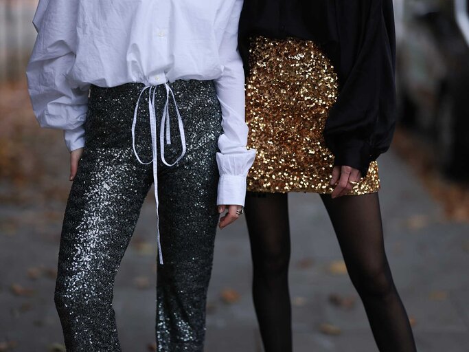 Zu sehen sind die Beine von zwei Frauen, denn ein Pailletten-Outfit tragen - einmal eine Hose, einmal ein Rock. | © Getty Images / Jeremy Moeller