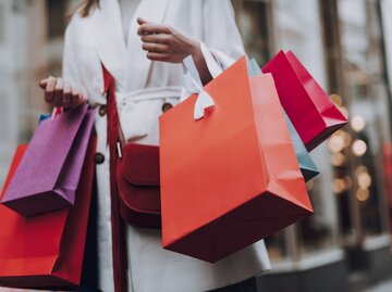 Nahaufnahme einer Frau, die Shoppingtüten hält | © Getty Images/YakobchukOlena