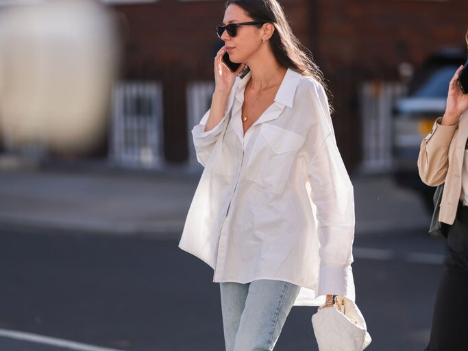 Frau trägt oversized Bluse und telefoniert | © Getty Images/Jeremy Moeller 