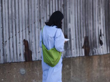 Frau mit einer grünen Crossbody Bag, seitlich von hinten fotografiert | © Getty Images/Jeremy Moeller