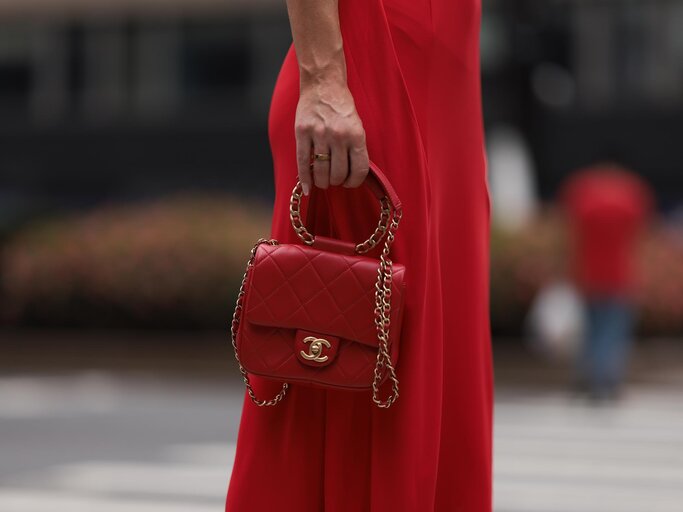 Streetstyle von Frau in rotem Kleid mit roter Chanel-Tasche | © Getty Images/Jeremy Moeller
