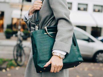 Frau hält grosse, grüne Handtasche unterm Arm | © Getty Images/Maskot