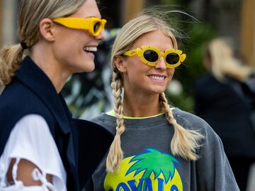 Streetstyle von zwei Frauen mit gelben Sonnenbrillen | © Getty Images/Christian Vierig