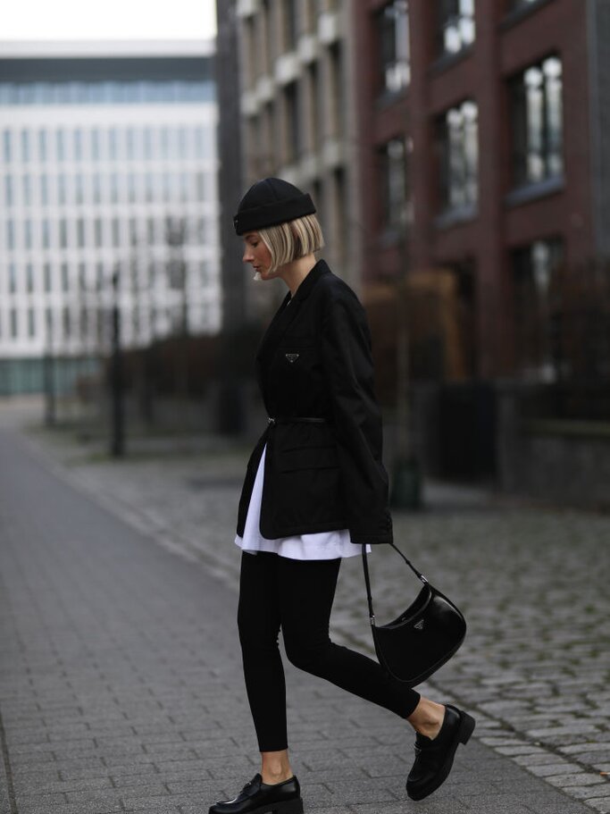 Frau trägt Leggings, Loafers, oversized Shirt und oversized Blazer sowie eine Mütze | © Getty Images/Jeremy Moeller