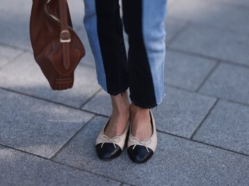 Streetstyle von Frau in zweifarbiger Jeans und Chanel-Ballerinas | © Getty Images/Jeremy Moeller