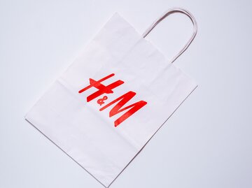 Weiße H&M-Tüte mit rotem Logo auf weißem Hintergrund | © AdobeStock/Алексей Филатов