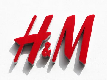 Rotes H&M-Logo auf weißer Wand in der Sonne | © AdobeStock/Ricochet64