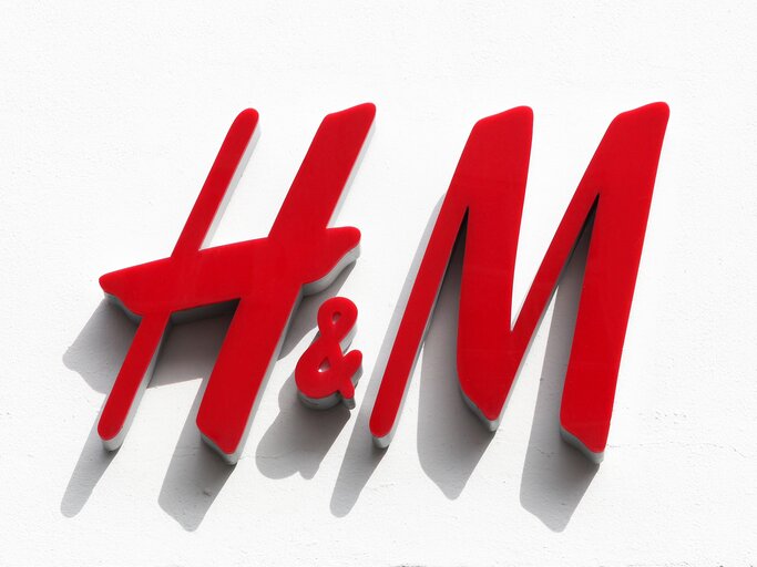 Rotes H&M-Logo auf weißer Wand in der Sonne | © AdobeStock/Ricochet64