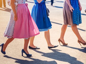 Frauen mit Dirndl und verschiedenen Schuhen gezeigt ab der Hüfte abwärts | © GettyImages/Nikada