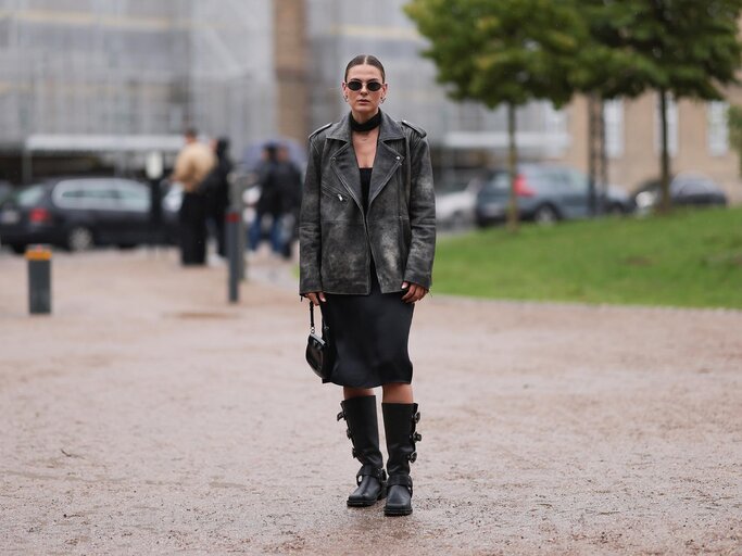 Streetstyle von Alessa Winter mit Bikerboots, einem knielangen Kleid und einer Lederjacke in Schwarz | © Getty Images/Jeremy Moeller