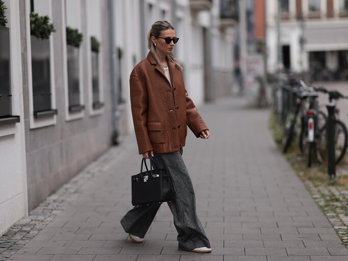 Streetstyle von Kathrin Bommann in Adidas Samba Sneakers, grauer Hose und brauner Lederjacke | © Getty Images/Jeremy Moeller