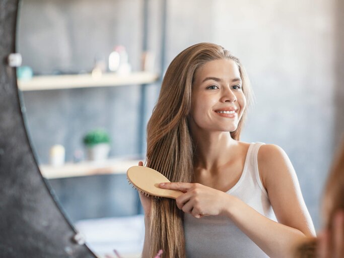 Junge Frau bürstet sich die Haare | © gettyimages.de /  Prostock-Studio