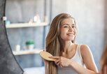 Junge Frau bürstet sich die Haare | © gettyimages.de /  Prostock-Studio