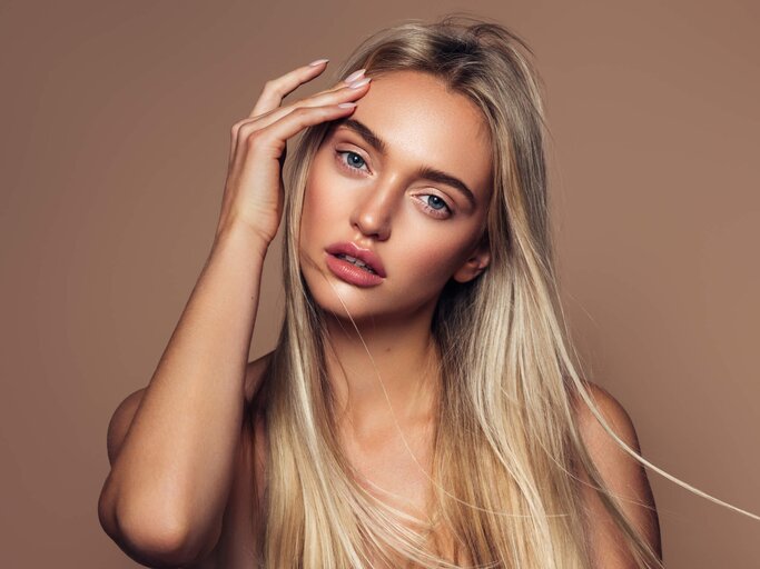 Schöne Frau mit langen blonden Haaren | © gettyimages.de / CoffeeAndMilk