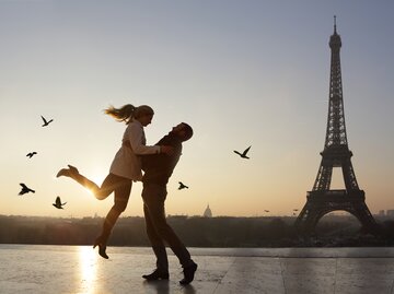 Ein Mann hebt eine Frau hoch vor dem Eiffelturm | © GettyImages/Peter Cade