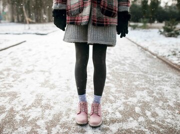 Beine einer Frau im tiefsten Winter mit Strumpfhose und Winterschuhen | © Getty Images/Mykhailo Lukashuk