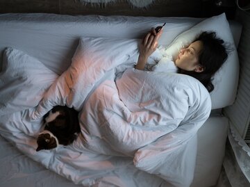 Frau liegt im Bett mit Handy in der Hand | © DimaBerlin - stock.adobe.com