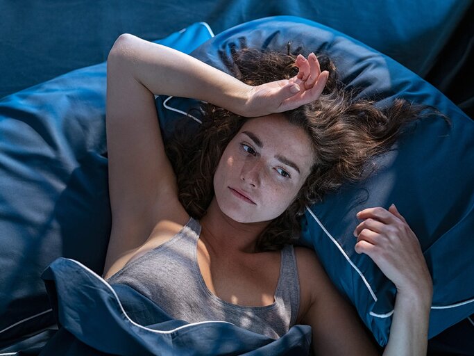 Frau liegt wach im Bett und grübelt | © Getty Images/Ridofranz