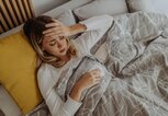 Frau liegt krank im Bett | © Getty Images/milan2099