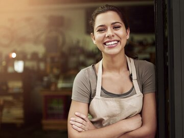 hübsche, junge Frau vor einem Geschäft | © iStock | Cecilie_Arcurs