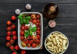 Feta und Tomaten in einer Ofenform, daneben eine Schale mit Nudeln | © gettyimages.de | Jane Vershinin