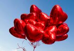 Rote Herzluftballons vor blauem Himmel | © gettyimages.de | Christian Adams