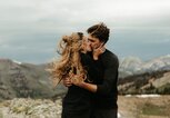 Paar küsst sich im Wind auf einem Berg | © gettyimages.de | Cavan Images