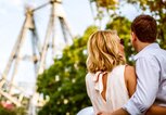 Pärchen von hinten fotografiert, geht auf eine Riesenrad zu. | © gettyimages.de | AleksandarNakic