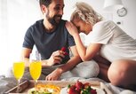 Mann macht seiner Freundin beim Frühstück am Bett einen Heiratsantrag | © gettyimages.de | Gpointstudio