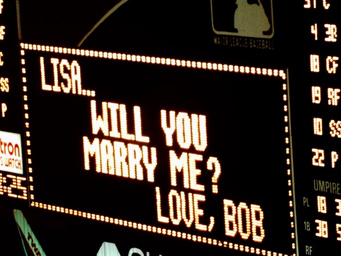 Auf einer schwarzen digitalen Anzeigetafel wird "marry me" in Leuchtschrift angezeigt | © gettyimages.de | Education Images