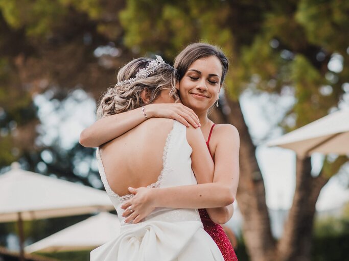 Trauzeugin umarmt die Braut | © gettyimages.de | Rubén Carbó / EyeEm
