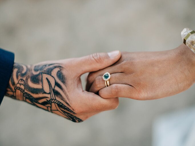 Tattoowierte Hand hält Hand mit Verlobungsring | © gettyimages.de | Sara Monika