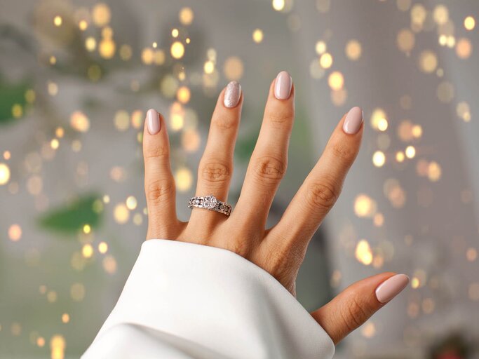 Hand einer Frau mit Diamantring vor verschwommenem Hintergrund | © gettyimages.de | AbElena