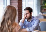 Mann stützt sein Gesicht beim Date auf die Hand und hat ein schlechtes Gefühl | © gettyimages.de | Prostock-Studio