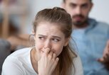 Junge Frau weint, im Hintergrund ist Mann zu sehen | © gettyimages.de| fizkes