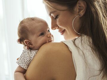Junge Mama hält Baby im Arm | © gettyimages.de | Nastasic