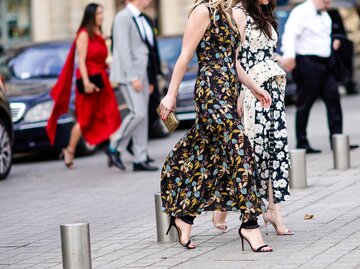 Street Style von zwei Besucherinnen der Paris Fashion Week 2018 in langen Kleidern mit Blütenprint und High Heels | © Getty Images / Edward Berthelot 