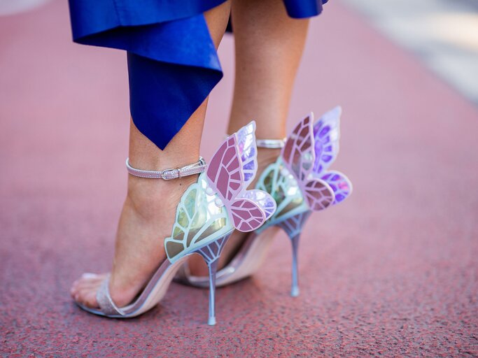 Detailaufnahme des Streetstyles von Bloggerin Gitta Banko mit High Heels mit pastellfarbenem Flügel-Detail in Düsseldorf | © Getty Images / Christian Vierig