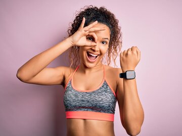 Fröhliche Frau in Sportbekleidung und SmartWatch am Handgelenk | © shutterstock/Krankenimages