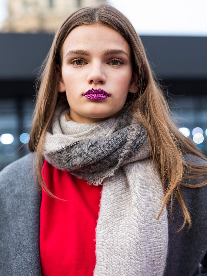 Model mit Glitzersteinen auf den Lippen | © Getty Images | Claudio Lavenia 