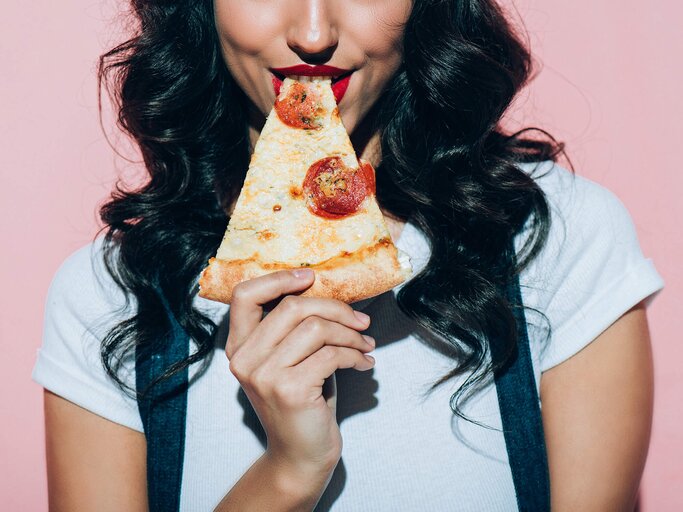 Frau mit Pizzastück | © iStock | LightFieldStudios
