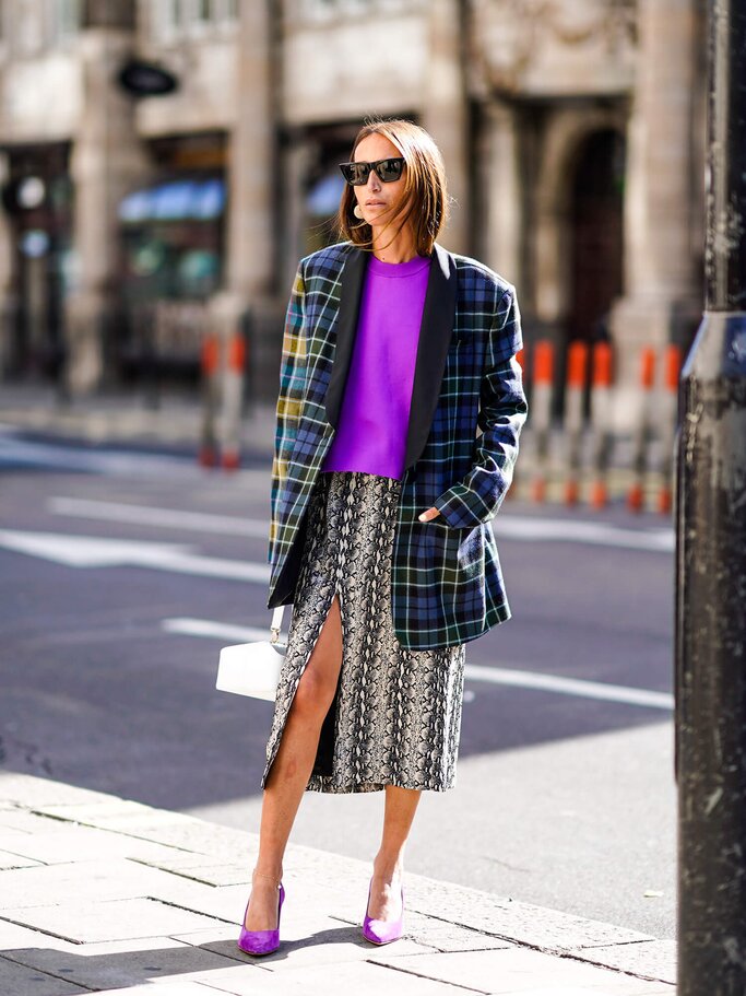 Chloe Harrouche mit kariertem Blazer und Snakeprint-Rock | © Getty Images | Edward Berthelot 